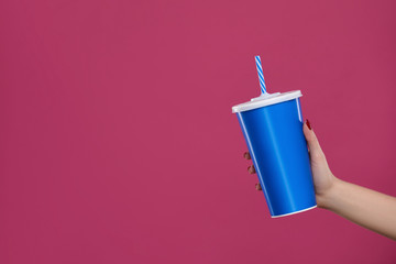 Crop of hand holding big blue cup with cola drink.