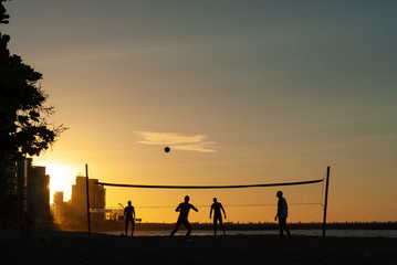 a group of friends playing volleyball on the brazilian beach of Fortaleza, Brazil