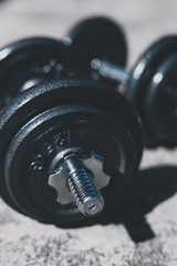 keeping fit and exercising outdoor, set of heavy dumbbells on concrete path in a backyard