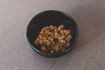 plant-based breakfast ideas, dark chocolate coated granola in black bowl