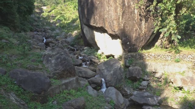 A huge stone bathed in sunlight looks like an apple, called Applestone by local people. Nature stock footage of Dooars, West Bengal, India