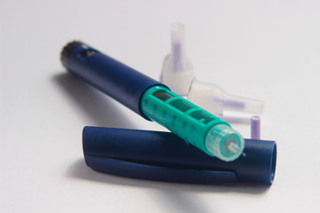 Close Up Photo, Blue and Green Insulin Pen at White Background