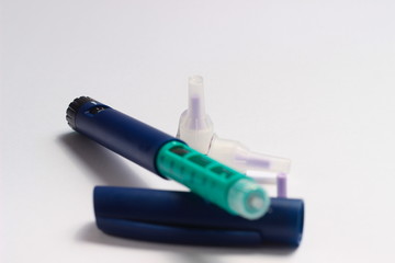 Close Up Photo, Blue and Green Insulin Pen at White Background