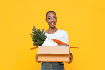 Happy smiling African American woman holding box moving stuff to the new house