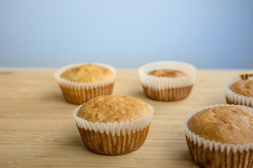 Homemade fresh baked Muffins on a wood table in a baking parchment paper.