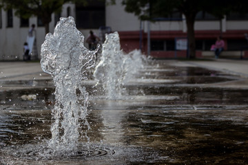 Fototapeta na wymiar Small thick water jets of a park fountain in the town of Knjazevac, eastern Serbia. Fast shutter, water splash, close up.