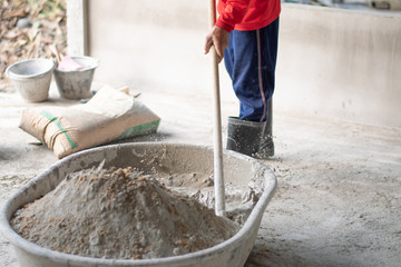 Construction workers are mixing cement and drops of water splashed out of the tank..