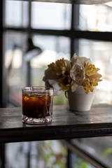 transparent glass of iced black coffee or americano on wooden table