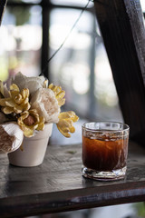 transparent glass of iced black coffee or americano on wooden table