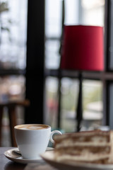 closeup capuccino at coffee shop in a wooden table