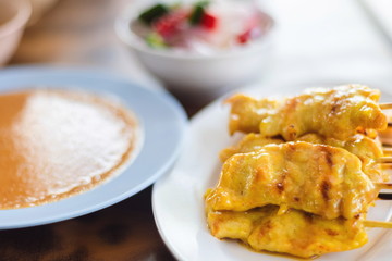 Close up pork satay Grilled pork sticks served with peanut sauce or sweet and sour sauce appetizer dish of traditional Thai street food recipe , Thailand street food Travel concept.