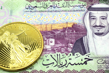 A macro image of a colorful riyal Saudi Arabian note with an American one ounce coin close up