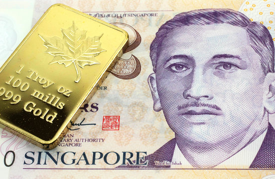 A macro image of a Singapore two dollar bill with a gold bar.  Shot close up.