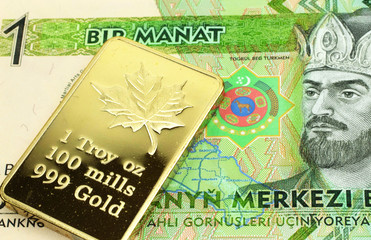 A macro image of a green one manat bill from Turkmenistan with a gold bar.  Shot close up.