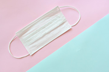 medical hygiene face mask on pink and blue pastel background