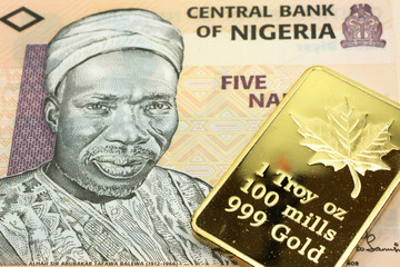A macro image of a peach colored Nigerian naira note with a gold bar.  Shot close up.