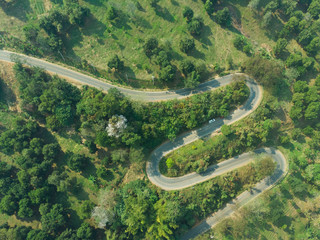 Aerial view of asphalt winding road in the forest mountain for background.Scenic view of Sharp curve road by drone safty drive and travel concept.