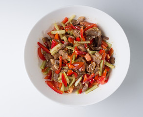 Korean meat salad in a white bowl. View from above. Juicy salad of beef, cucumbers, peppers