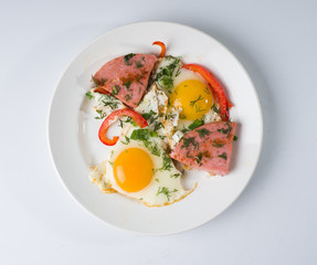 Fried sausage fried eggs on a white round plate. Top view