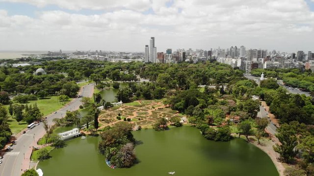 Aerial panoramic view of Bosques de Palermo in Buenos Aires. Drone flying foward over the lake with a cloudy sky as background