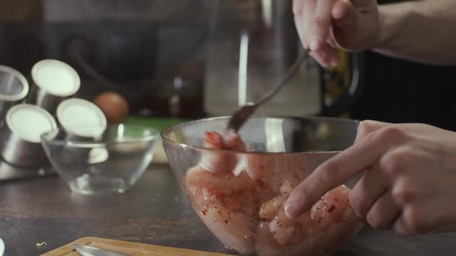 Mixing chicken meat on kitchen, shallow depth of field, slow motion