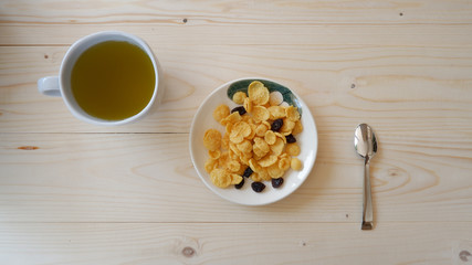 A cup of green tea and snack on wooden table