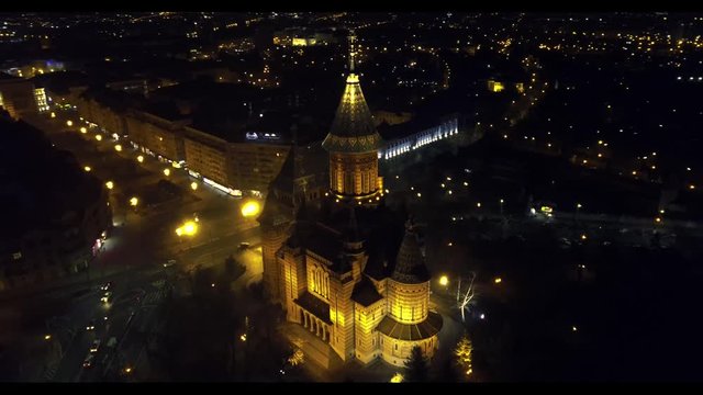 drone orbit cathedral in city, night time