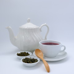 Top view mockup a cup of tea and tea leaf on the white desk. Free space for your text.