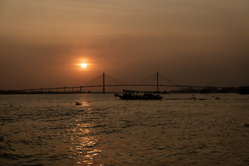 Fototapeta na wymiar Bridge and boat at sunset 