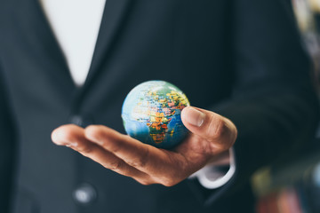 Business man holding earth globe model in hand and - Business global and travel around the world or save the world concept