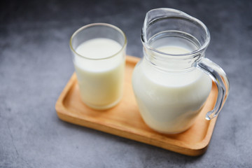Fresh milk natural in a glass jug on wooden tray - Serving breakfast milk concept