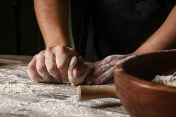 Man kneading dough in kitchen, closeup