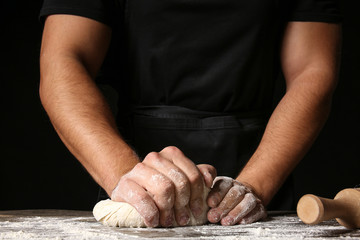 Man kneading dough in kitchen, closeup