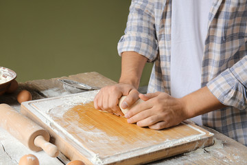 Man kneading dough in kitchen