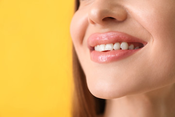 Young woman with beautiful smile on color background, closeup