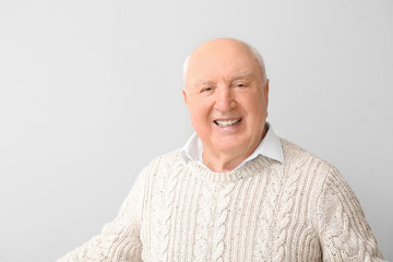 Obraz premium Portrait of elderly man on light background