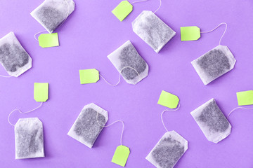 Many tea bags on color background