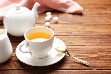 Cup of tasty tea on wooden background