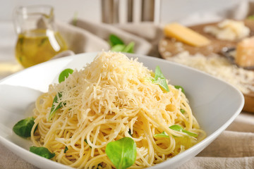 Plate with tasty pasta and cheese on table, closeup