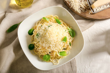 Plate with tasty pasta and cheese on table