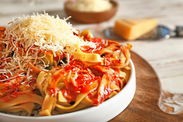 Plate with tasty pasta and cheese on table, closeup