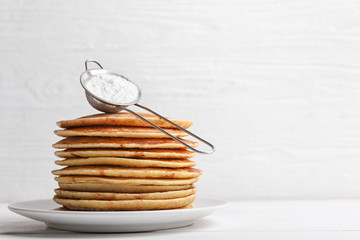 Stack of tasty sweet pancakes on white table