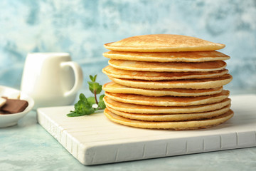 Stack of tasty pancakes on table
