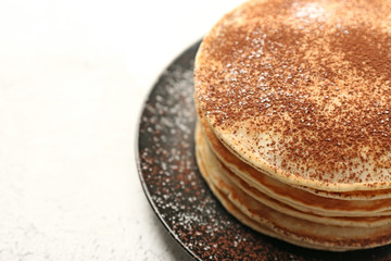 Stack of tasty sweet pancakes on white table