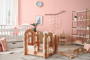 Wooden take-apart playhouse in interior of children's room