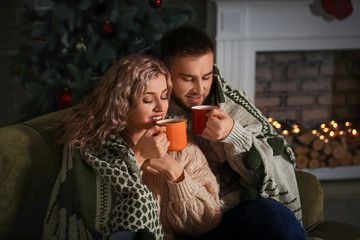 Happy young couple drinking hot cocoa at home