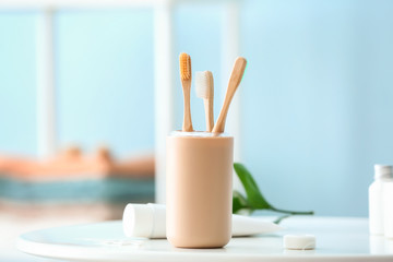 Tooth brushes in holder on table in bathroom
