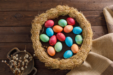 Still life many colorful easter eggs on a wooden background. Rustic. Decoration from natural fabrics and herbs. Easter celebration concept. Flat lay