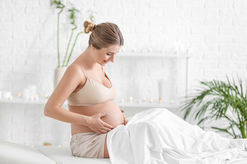 Young pregnant woman resting in spa salon