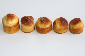 A row of cakes on a white background. Freshly baked cakes without icing and decorations. Easter.